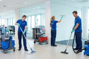 Trois professionnels nettoyant un hall de bureau